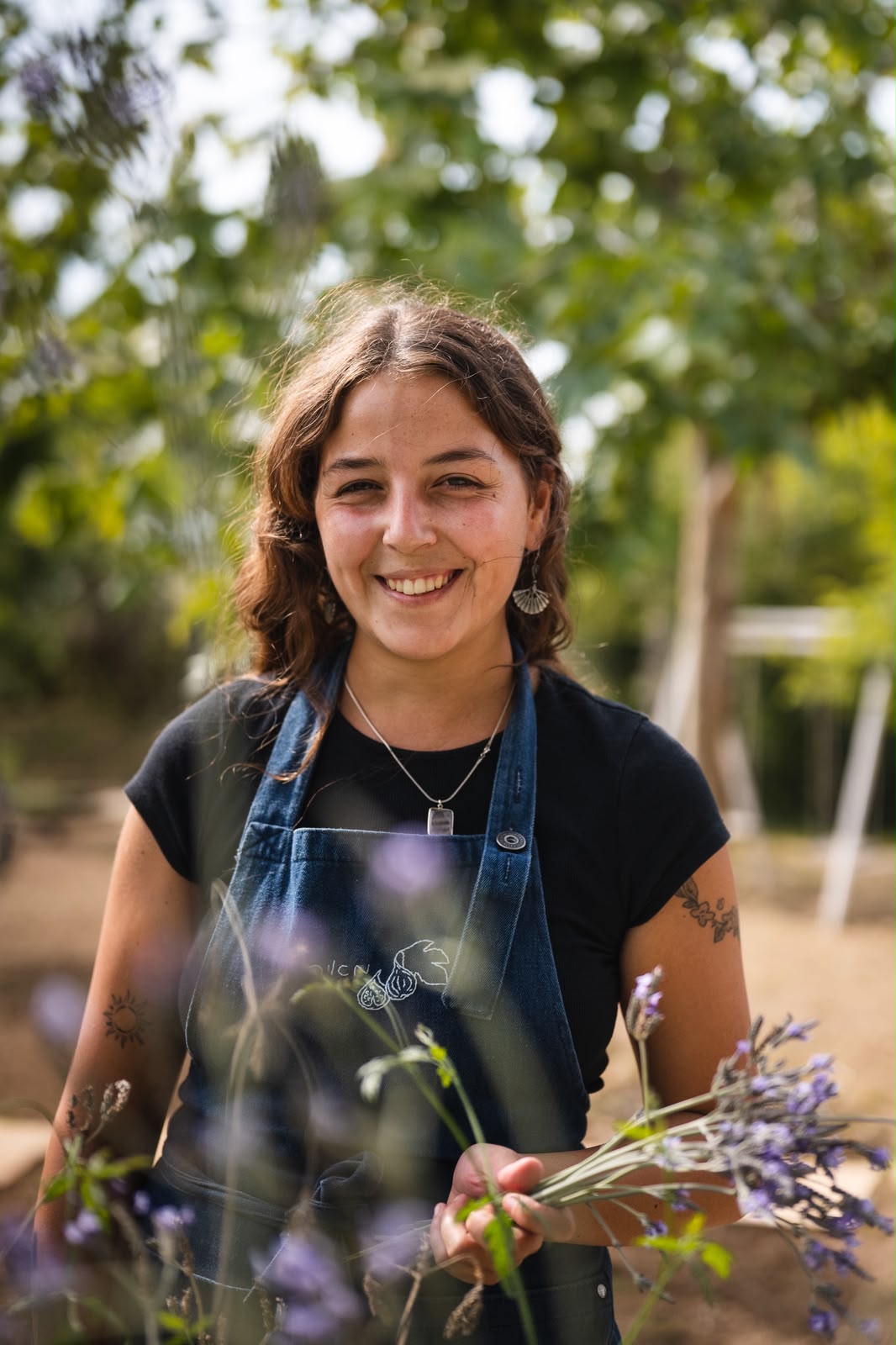 מאיה בן חמו לבושה סינר ג׳ינס בין עשבי לבנדר בגינה